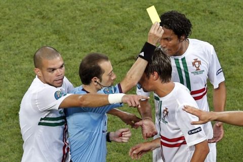 Referee Cuneyt Cakir of Turkey, second left, books Portugal's Fabio Coentrao, as his teammates Pepe and Bruno Alves react beside them during the Euro 2012 soccer championship semifinal match between Spain and Portugal in Donetsk, Ukraine, Wednesday, June 27, 2012. (AP Photo/Darko Vojinovic)